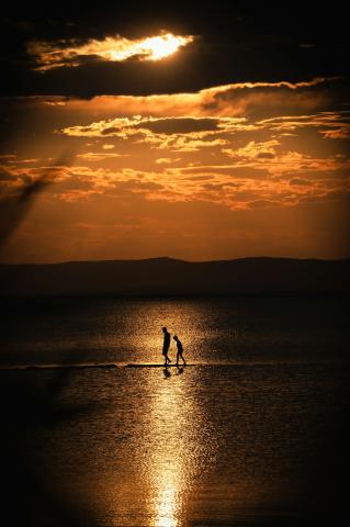 Adult and child walking in the sun